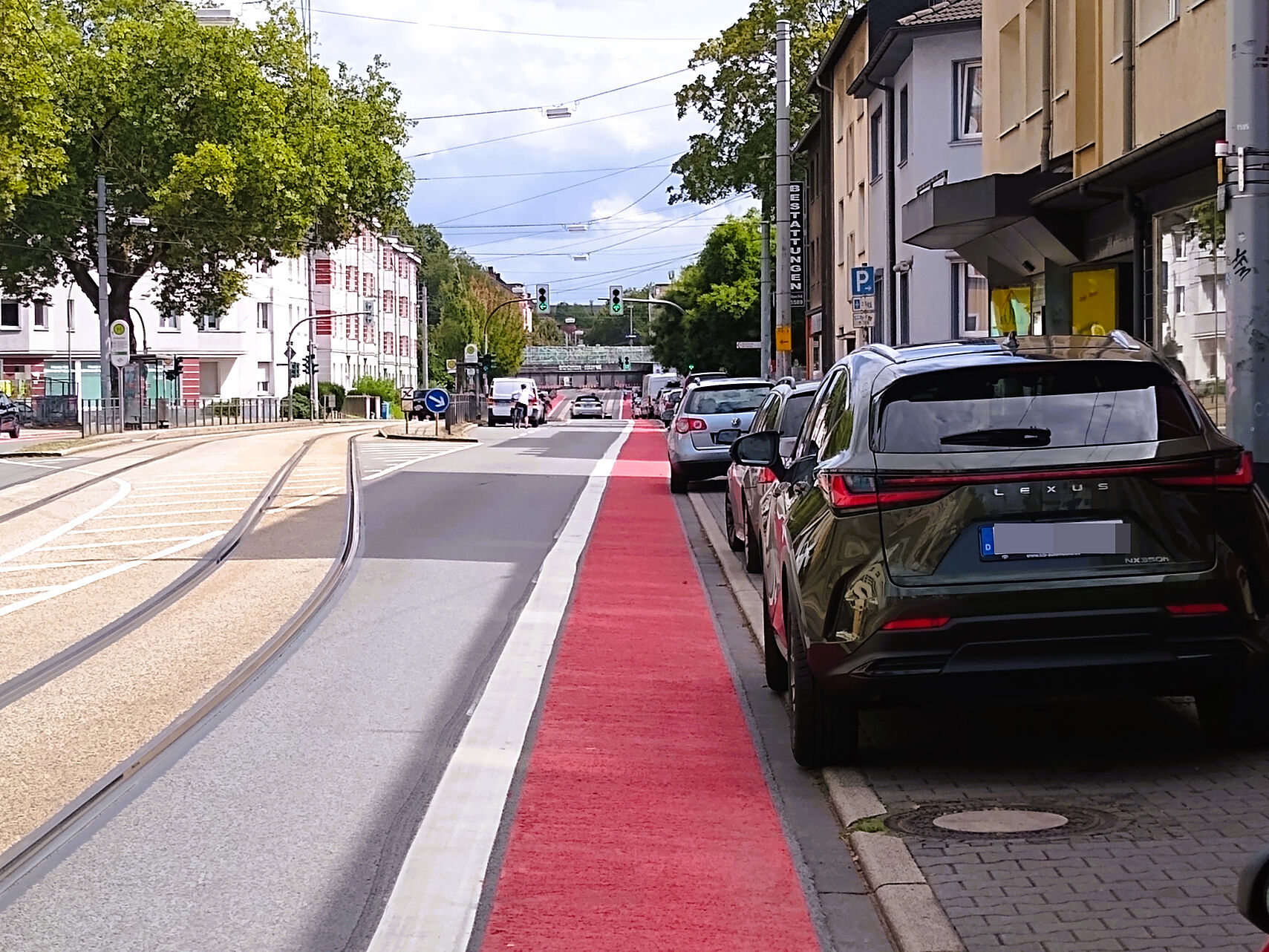 Rot markierter Sicherheitsabstand neben parkenden Autos