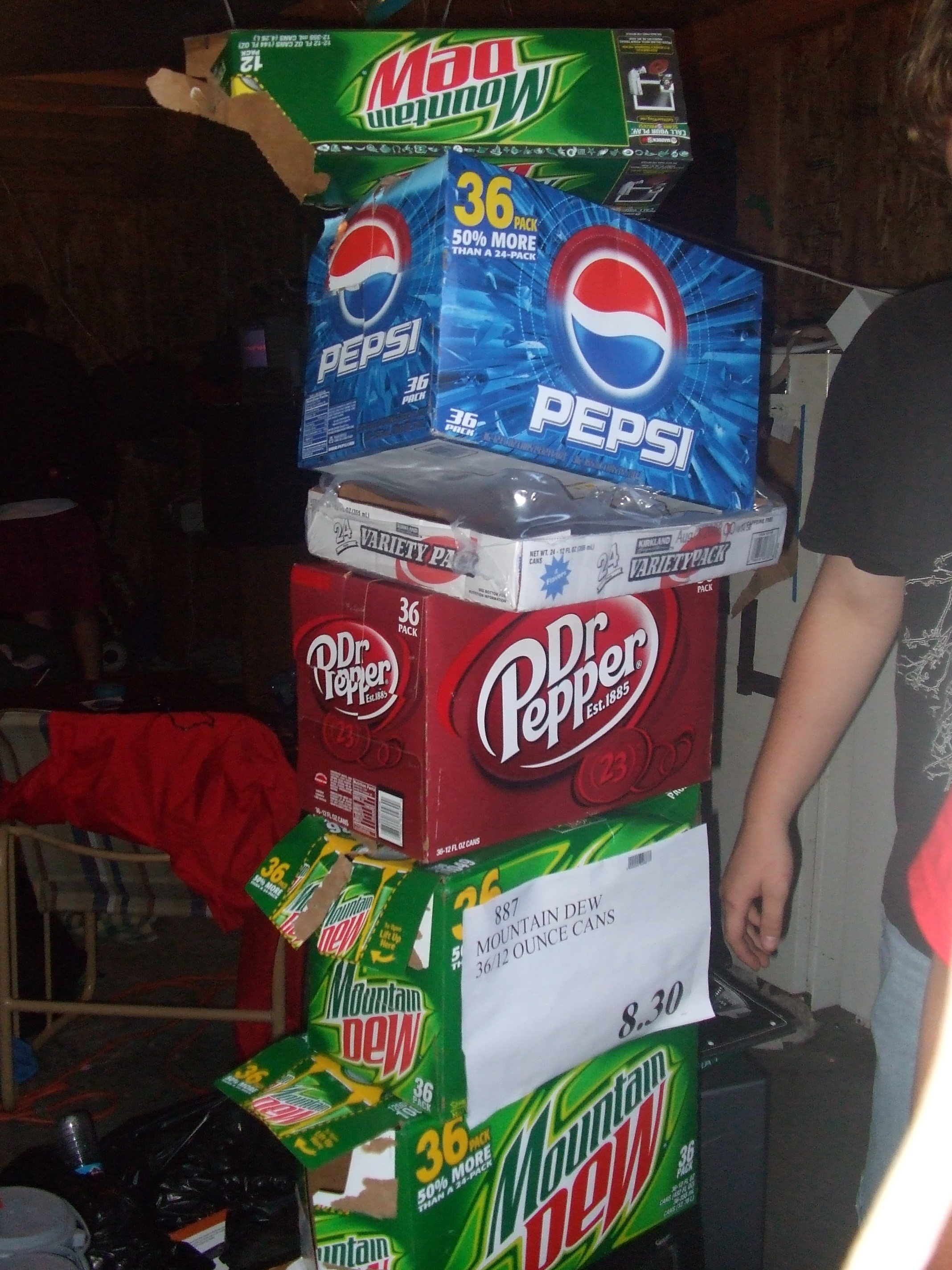 A tower of empty 36 packs of soda reaching to the ceiling